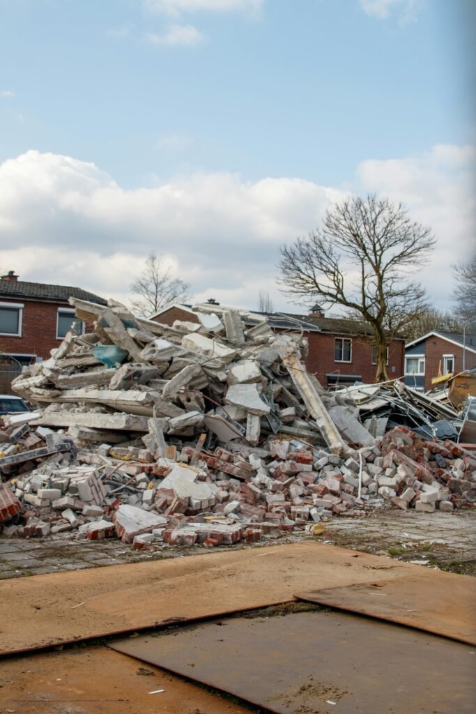 Piles of concrete and bricks from demolished buildings in a residential area.